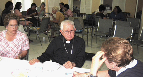 In this 2010 photo, Bishop Agustín Román, Auxiliary Bishop of Miami, speaks with members of the Teresian Association at the Poveda Center in Miami.