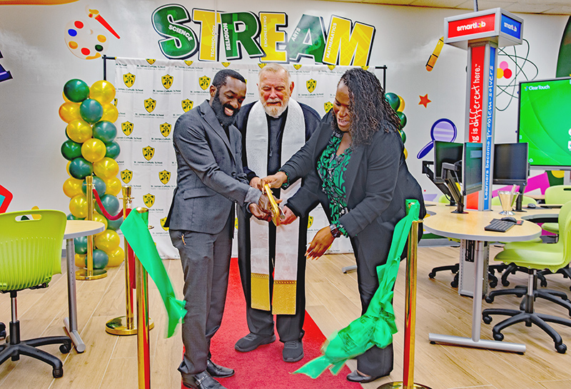 Archbishop Thomas Wenski (center), along with Father Fenly Saint-Jean, pastor of St. James Church, and Lori Bryant, principal of the school, cut a green ribbon to officially open the new SmartLab at St. James School in North Miami, Jan. 22, 2025.