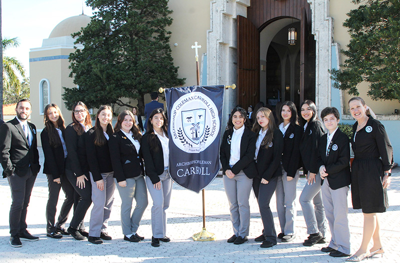 Students from Archbishop Coleman Carroll High School in Miami, accompanied by Nigel De La Rosa, left, and Mariela Matamala, right, pose in front of St. Mary Cathedral in Miami before the start of the All Schools Mass for Catholic Schools Week. Sixty-five schools in the Archdiocese of Miami were represented at the annual Mass celebrated by Archbishop Thomas Wenski Jan. 29, 2025.