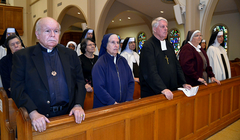 Religious marking jubilees of their profession of vows stand up during the Mass for the World Day of Prayer for Consecrated Life, celebrated Feb. 2, 2025, at St. Mary Cathedral. From left: Marist Brother George di Carluccio, a jubilarian of 50 years; Sister Eva Perez-Puelles of the Daughters of Charity of St. Vincent de Paul, a jubilarian of 50 years; Marist Brother John Healy, a jubilarian of 50 years; Sister Ana Pia Cordua of the Servants of the Pierced Hearts of Jesus and Mary, a jubilarian of 25 years,  and Sister Mary Louise of the Carmelite Sisters of the Most Sacred Heart of Los Angeles, a jubilarian of 25 years.