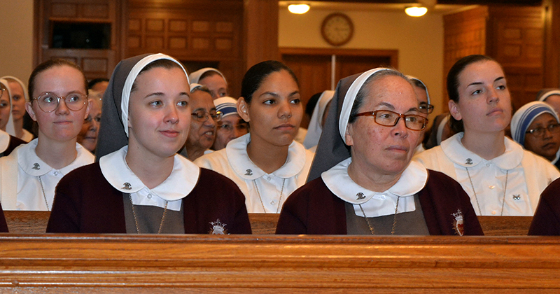 Sisters and postulants of the Servants of the Pierced Hearts of Jesus and Mary listen to Archbishop Wenski during the annual Mass for the World Day of Prayer for Consecrated Life at St. Mary Cathedral in Miami Feb. 2, 2025. The Mass was also attended by representatives of the various orders of women and men serving in the Archdiocese of Miami.