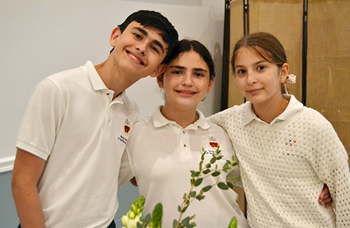 Students of Our Lady of Lourdes School in Miami, Fernando Grane, his sister Lucia, and Valentina Rodriguez, pause while serving honorees at a dinner following the annual Mass for the World Day of Prayer for Consecrated Life, celebrated Feb. 2, 2025, at St. Mary Cathedral, Miami.