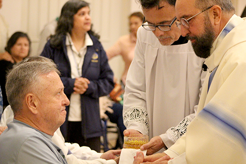 Francisco Anduiza (left) receives the anointing of the sick from Father Francisco Garcia (far right) during the Healing Mass at Our Lady of Lourdes Parish in Miami Feb. 11, 2025, the feast day of Our Lady of Lourdes and World Day of the Sick.