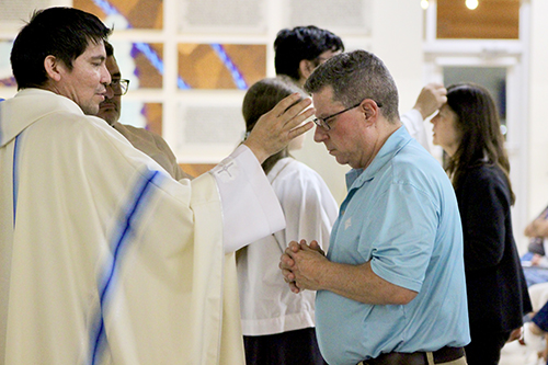 John Cooper (right) receives the anointing of the sick from Father Fredy Yara, parochial vicar at Our Lady of Lourdes parish in Miami, during the Healing Mass at the parish Feb. 11, 2025, the feast day of Our Lady of Lourdes and World Day of the Sick.