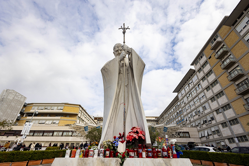 A statue of St. John Paul II stands outside the main entrance of Rome's Gemelli hospital Feb. 18, 2025. Pope Francis has been an inpatient at the hospital since Feb. 14. (CNS photo/Pablo Esparza)