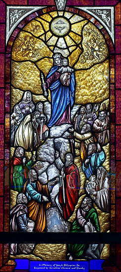 Mary, Help of Christians holds a scepter as she leads a variety of people in this window at St. Matthew Church in Hallandale.