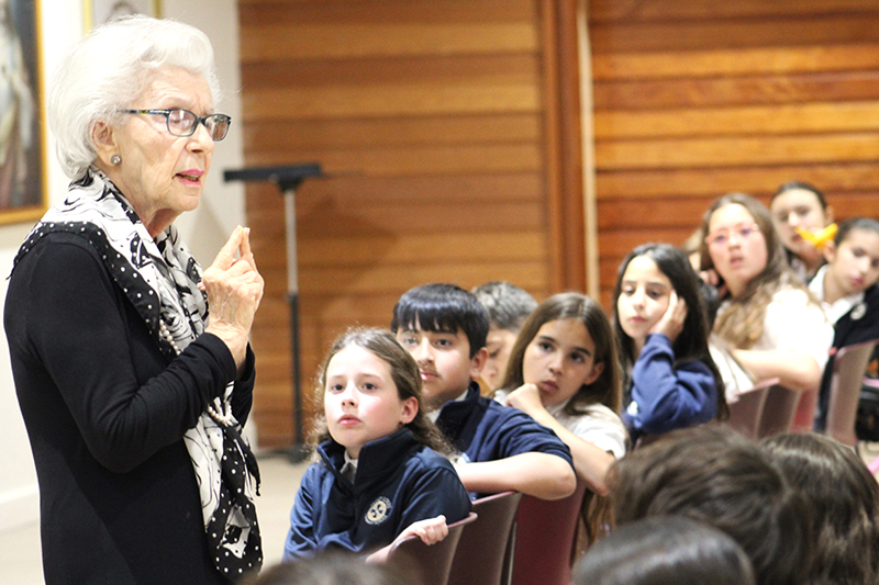 St. Louis Covenant School fifth graders listen to the testimony of Holocaust survivor Judy Rodan, who at age six was separated from her family, given a new identity, and taken care of by nuns in a convent during World War II. Rodan was invited to share her story at the Holocaust Remembrance Day event held on March 3, 2025.