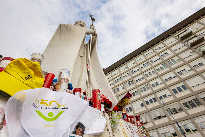 A scarf from a member of Italy's Movement for Life is seen on March 8, 2025, at the base of a statue of St. John Paul II outside Rome's Gemelli hospital where Pope Francis is receiving treatment.