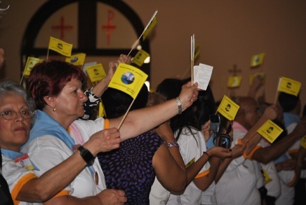 Devotees of St. John Bosco wave flags welcoming the saint's relics to Miami's St. John Bosco Church.