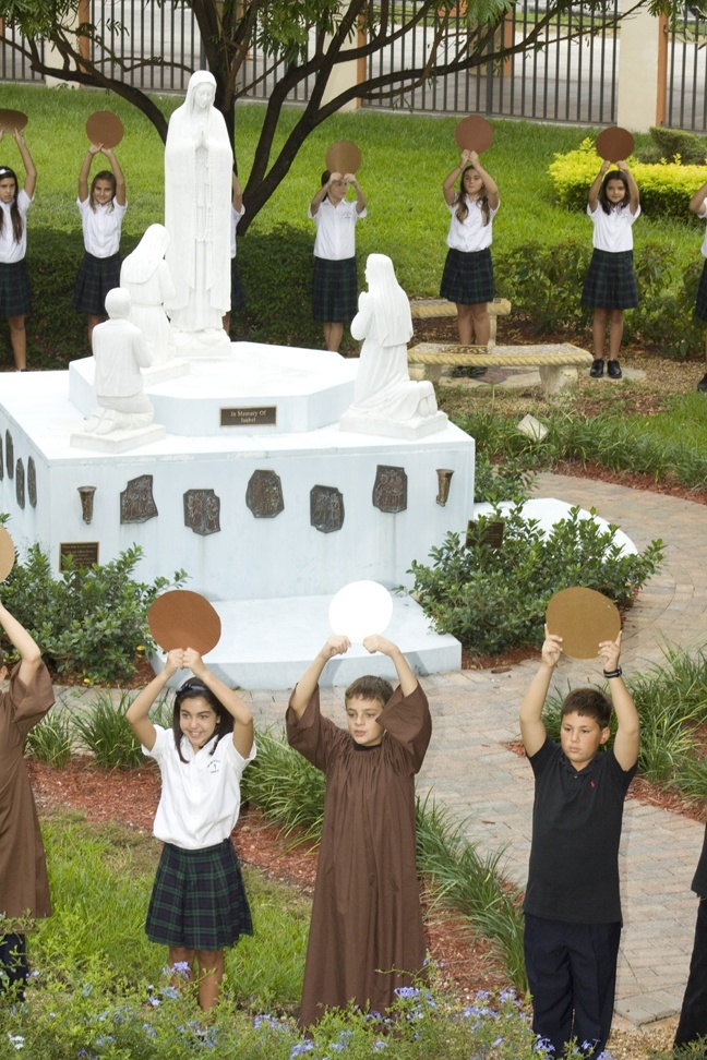 From left, Bianca Perez, Brandon Blanco and Brandon Becerra, sixth grade students at Our Lady of the Lakes School in Miami Lakes, represent beads in a "living rosary" prayed by the entire school Oct. 12.