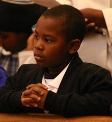 Berthony St. Louis, a student at St. Mary Cathedral School in Miami, prays during a school-wide Mass celebrated Jan. 13 for the victims of the earthquake in Haiti.