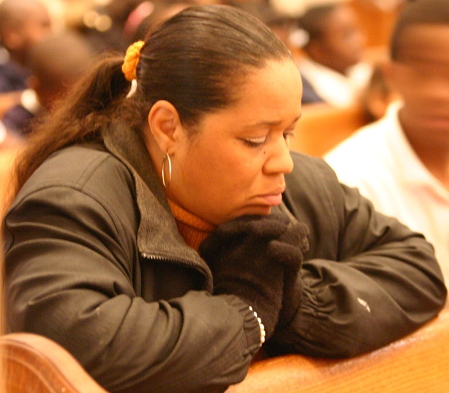 Marie Claire Kernizan, secretary at St. Mary Cathedral School, prays during the Mass Jan. 13 for victims of the earthquake in Haiti. She knew her husband was safe but had not heard from her mother or brother, who live in Port-au-Prince.