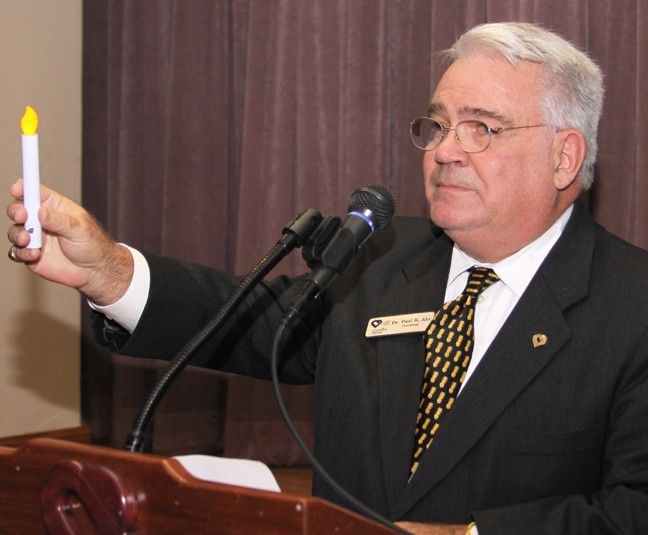 Paul R. Ahr, president and chief executive officer of Camillus House, holds up a candle and praises the work of the shelter's staff, volunteers and supporters. May your glow warm us for as long as the poor are with us, he said.