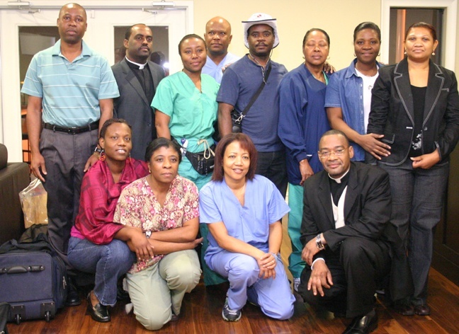 Father Reginald Jean-Mary, second from left, back row, and Father Robes Charles, first from right, kneeling, pose with members of the medical team before flying to Haiti Jan. 23.