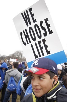 Belen Jesuit student Francisco Villafae, 14, has his sign stuck into his backpack.