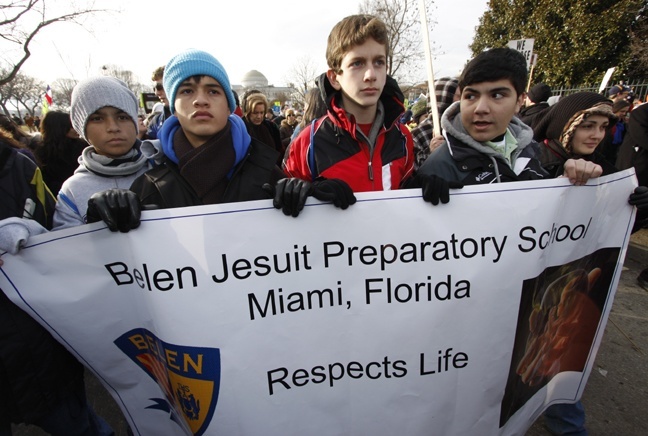 From left, Belen Jesuit Preparatory School students Gerry Portella, Julian Ochoa, Enrique Menendez, Giovanni Rodriguez and their teacher, Sylvia Davalos, escort their banner towards the U.S. Supreme Court.