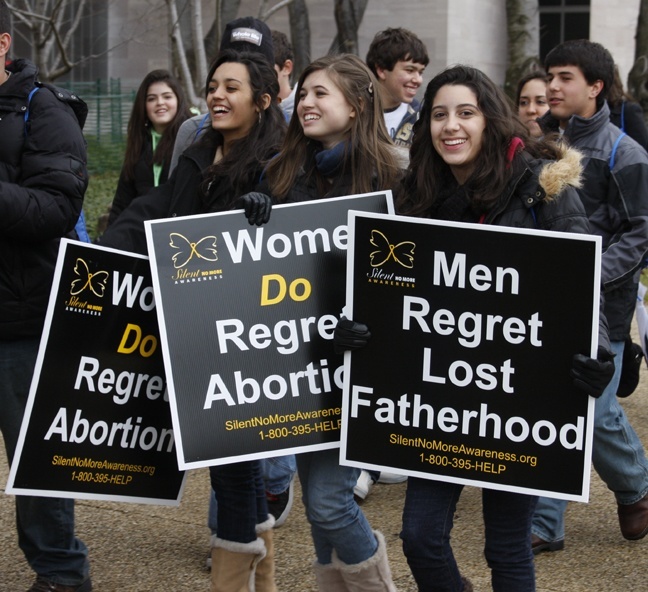 Archbishop McCarthy High School students, from left, Alannah Alfonso, 16, Jennifer Wilford, 16, and Yimalisse Nazario, 17, walk joyfully towards the National Mall to participate in the March for Life.