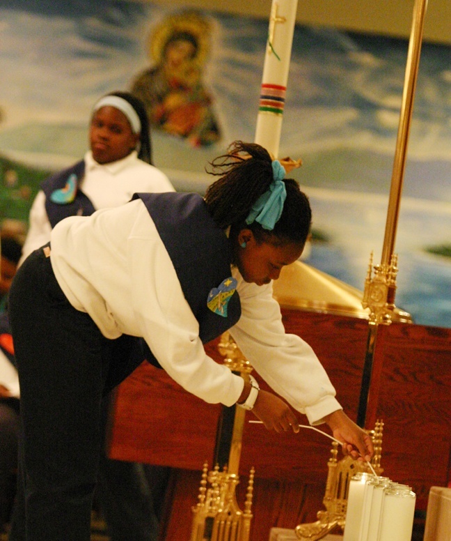 Students from St. Mary Cathedral School light prayer candles during the interfaith service for Haiti.