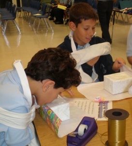 Students from Mother of Our Redeemer Catholic School in Miami attempt to wrap a present without the use of their hands during the Schott Center's presentation of Welcome to My World.