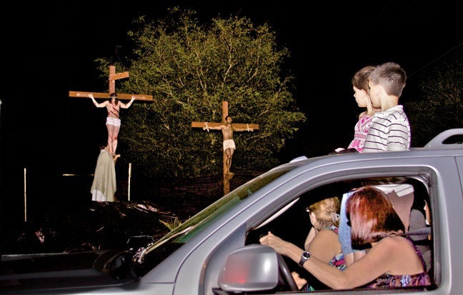 A carload of women and children stop to look at the scene depicting Jesus' crucifixion.