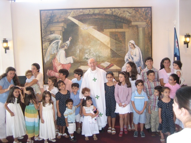 Jesuit Father Amando Llorente is shown here after an Easter Mass surrounded by children of members of the Agrupacion.