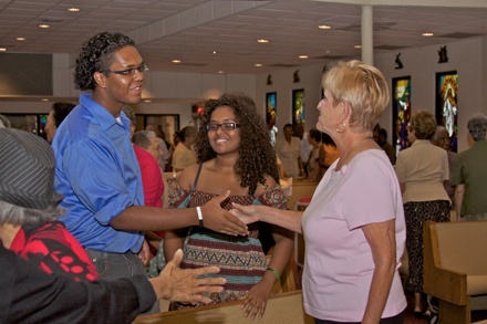 Broward County residents hailing from Jamaica exchange the sign of peace during the Mass.