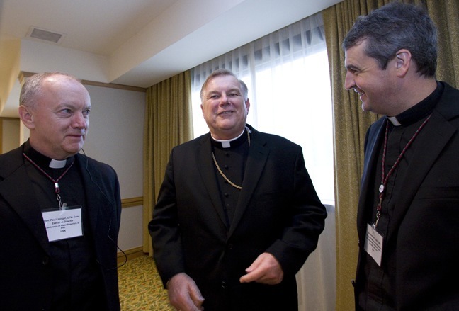 Archbishop Thomas Wenski shares a laugh with Franciscan Father Paul Lininger, executive director of the U.S. Conference of Major Superiors of Men, left, and Oblate Father Andrew Small, a member of the U.S. bishops' Subcommittee on the Church in Latin America.