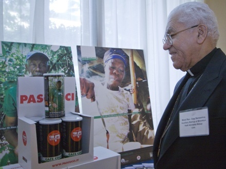 Auxiliary Bishop Guy Sansaricq of Brooklyn, N.Y., looks over a display touting St. Thomas University's support of a fair trade coffee cooperative in Miami's sister diocese, Port-de-Paix, Haiti.