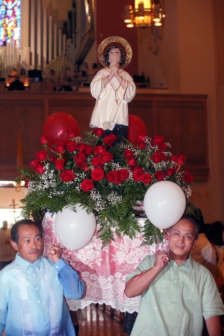 Ernesto Olivos, left, and Hector Villamor carry a statue of San Lorenzo Ruiz into St. Mary Cathedral.