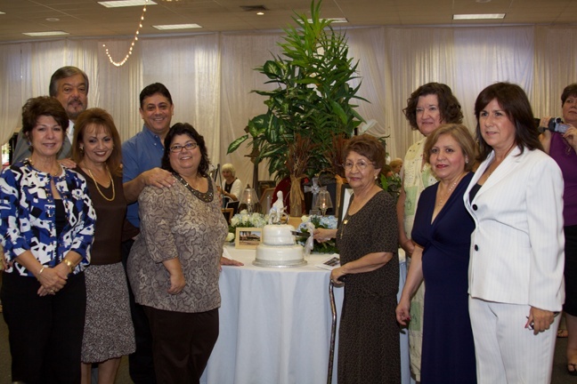 Gathered around an anniversary cake, some of the founding parishioners of St. Bonaventure Parish in Davie pose for a photo after the anniversary Mass.