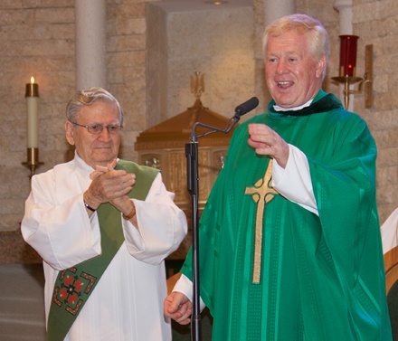 Father Edmond Prendergast addresses parishioners are he celebrates 25 years as pastor of St. Bonaventure Parish in Davie. Next to him is Deacon Art DeNunzio.