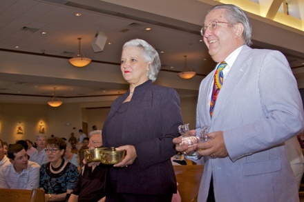 Jim and RoseMary Bossman, founding parishioners, bring up the offertory during the Mass.