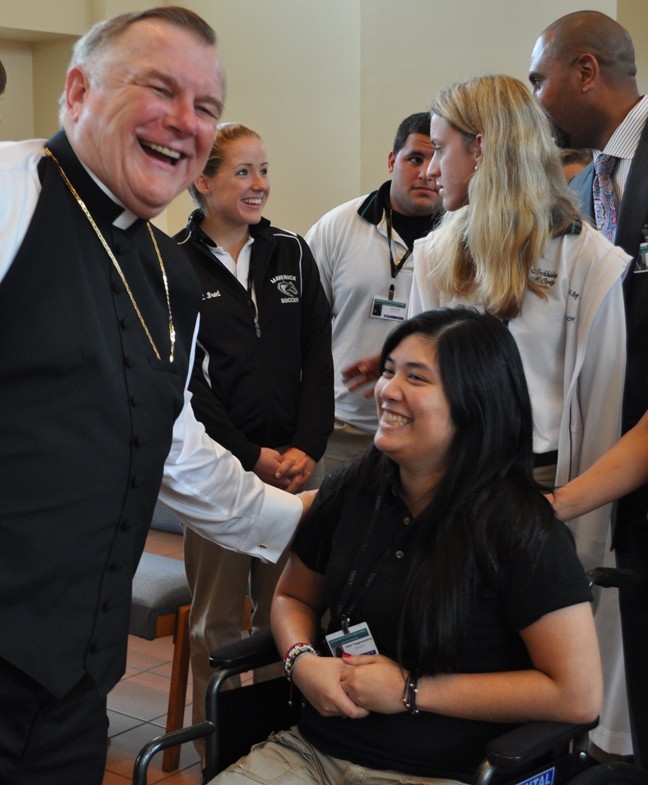 Archbishop Thomas Wenski greets Palida Pongpluempitichai, known as Monica Pong, a McCarthy High School senior who was injured last year in a freak car accident. She is once again attending classes at the school.