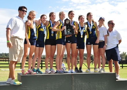 Carrollton cross country runners pose with their coaches on the winners' stand.