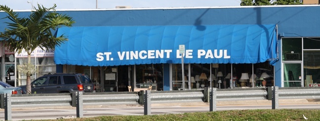 The blue and white-lettered canopy of the St. Vincent de Paul Society's thrift store is visible at the south entrance to Hialeah, just across the river from Miami Springs.