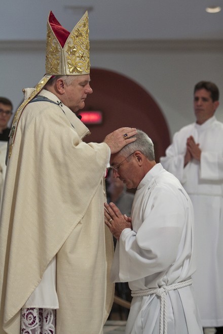 Archbishop Thomas Wenski lays hands on George Labelle, calling down the Holy Spirit and ordaining him a permanent deacon.