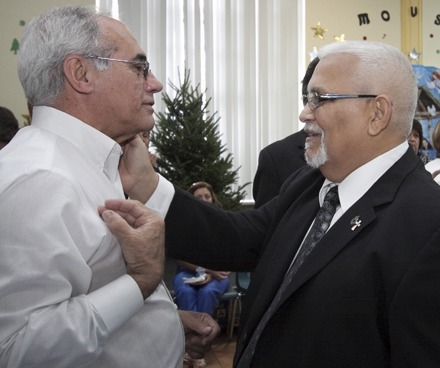 Newly-ordained Deacon Antonio Perez-Noy, right, imparts a blessing to a friend at the reception which followed the ceremony.