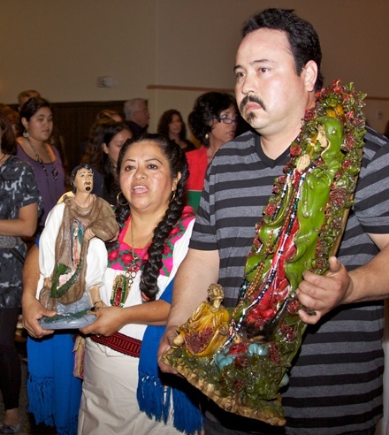 Lucy Castillo and family carry a statue of Our Lady of Guadalupe that came from the Basilica of Guadalupe in Mexico City into Little Flower Church. The statue was welcomed by hundreds of people from the community.