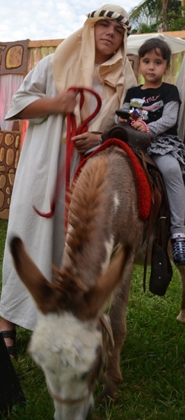 As part of the living Nativity, donkey owner Nicholas Toledo, left, gave out rides to visitors. The rider in this case is Alexandra Holguin of St. Louis Parish.