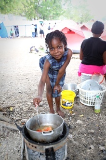 A child in Port-au-Prince prepares a meal in an earthquake refugee camp sponsored by the Italian-based Salesian Missionary Sisters there.