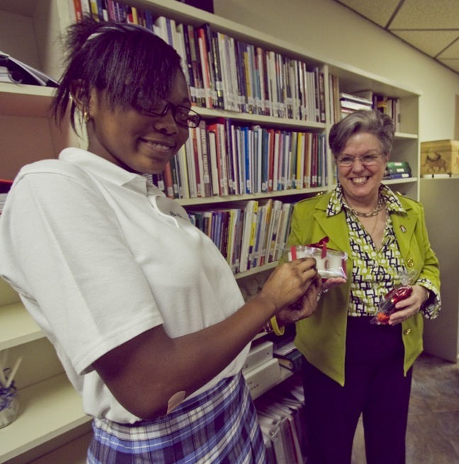 Keyanna Francois, an eighth-grader at St. Mary Cathedral School in Miami, hands candies and candles to Hope Sadowski, administrative executive assistant in the Department of Christian Formation.