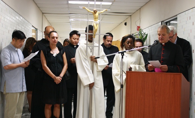 After walking in procession from St. Anthony Chapel on campus, Msgr. Franklyn Casale reads the prayer of rededication of Kennedy Hall, the first classroom building on St. Thomas University's campus.