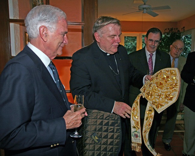 Archbishop Thomas Wenski is presented with a new mitre by Fernando Garcia Chacon y Chacon, president of the Cuban Association of the Knights of Malta, left, as his fellow knights Juan Calvo, center, and Alfredo Hernandez, look on.