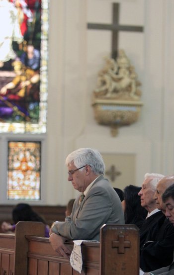 Chief Federal Judge Fred Moreno prays during the Red Mass celebrated by Archbishop Thomas Wenski at Gesu Catholic Church in downtown Miami.