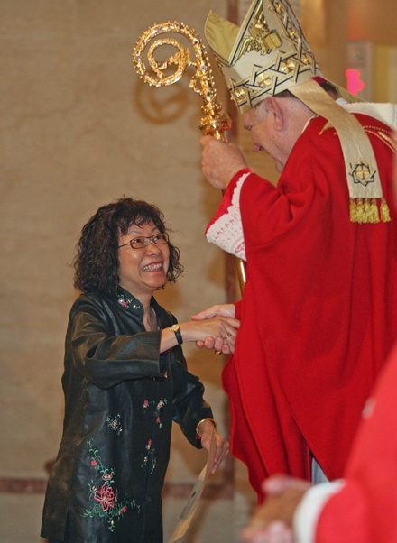 Kit Kwok, active in evangelization ministry at St. Kevin Parish in Miami, receives her certificate from Archbishop Wenski.