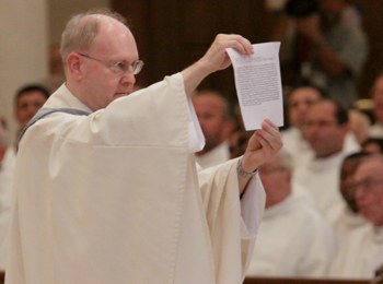 Father Michael Morgan, chancellor of the Diocese of St. Augustine, holds up for the congregation the apostolic mandate naming Bishop Estevez to St. Augustine.