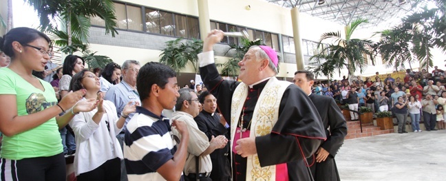 Archbishop Thomas Wenski sprinkles holy water on the large group of 190 pilgrims going to World Youth Day, most of them from the Archdiocese of Miami, along with a few from the Diocese of Orlando, the Diocese of Venice and the Turks and Caicos islands.