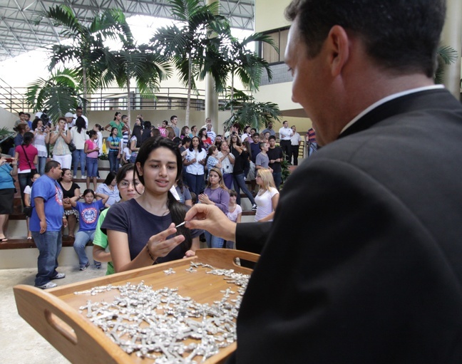 Father Richard Vigoa, master of ceremonies and priest-secretary to Archbishop Thomas Wenski, distributes blessed crucifixes to young pilgrims from the archdiocese and other parts of Florida who left Aug. 11 for World Youth Day in Madrid, Spain.