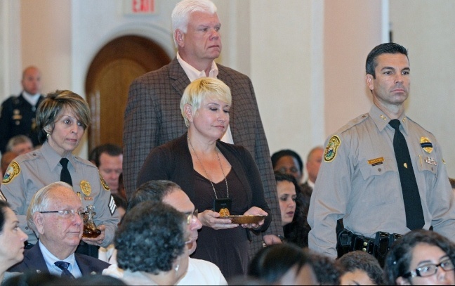 Among those who carried the offertory gifts were family and close friends of officers killed in the line of duty. From left to right: Miami-Dade Police Sgt. Rosie Diaz, close friend of slain officer Amanda Haworth; Elizabeth Somohano, widow of slain Miami-Dade Police officer Jose Somohano; Chief Juan Perez, Miami-Dade Police Dept., and (back), retired Miami-Dade Police Director James Loftus.