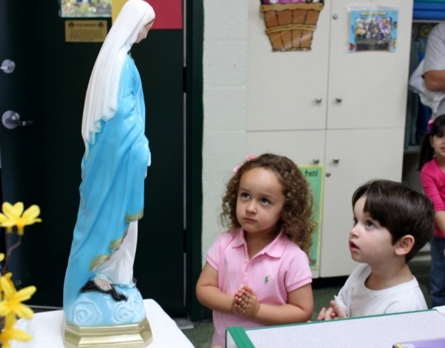 Elizabeth Braceras and Matthew Isaza, students at St. Kevin Catholic Schools Pre-K3A class, quietly pray to the Pilgrim Virgin in their classroom.